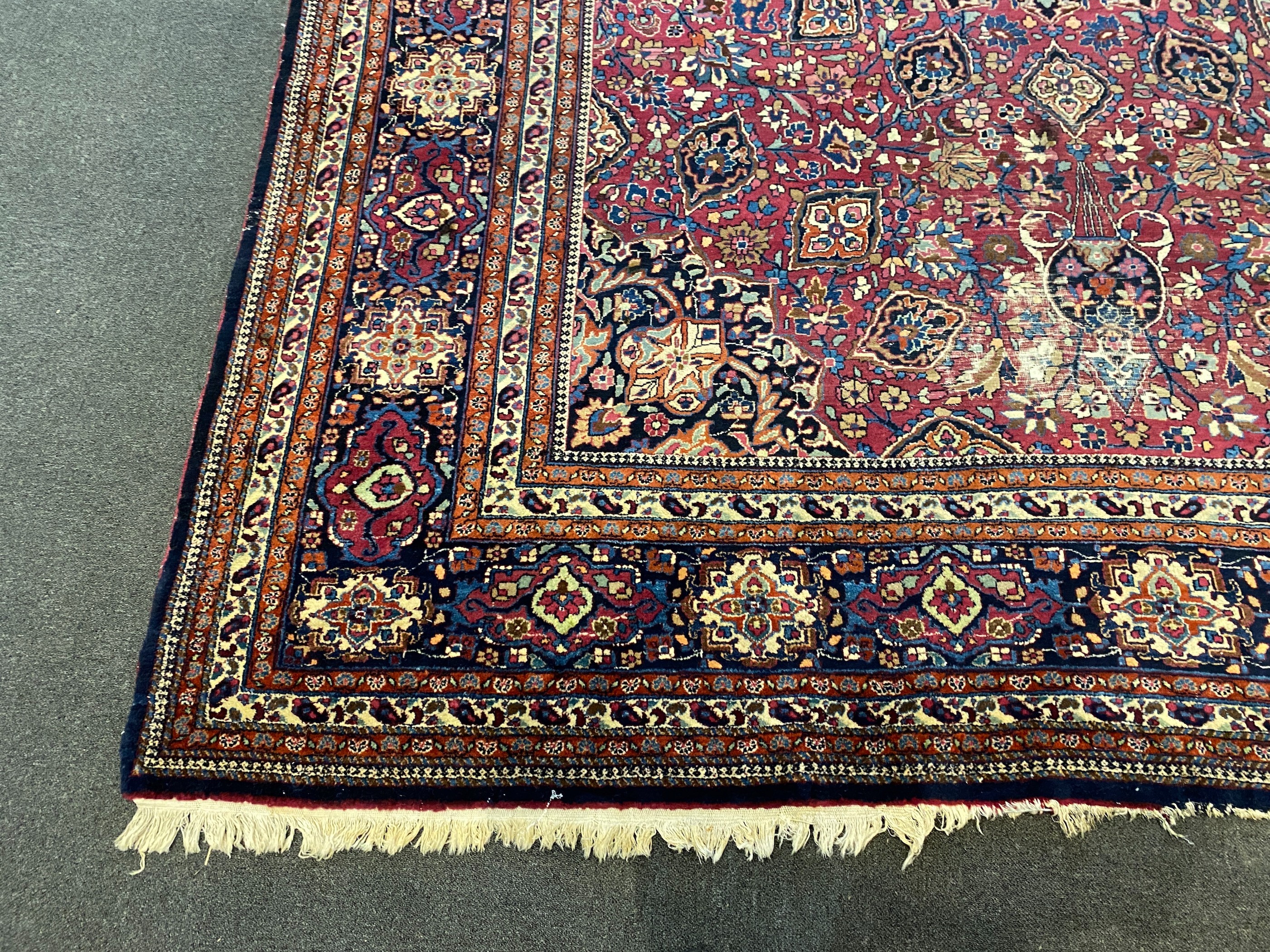 An early 20th century Heriz burgundy ground carpet